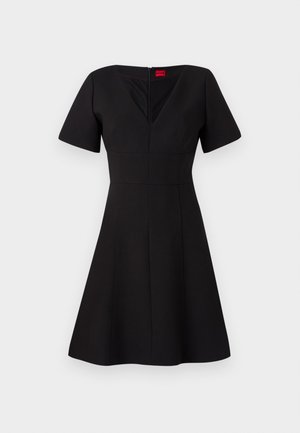 Robe noire avec un corsage ajusté et une jupe évasée. Comprend des manches courtes, un décolleté en V, une fermeture éclair au dos et des coutures créant une silhouette structurée.