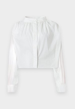 Bluza albă cropped cu mâneci lungi, cu dungi subțiri verticale, pieptar plisat, guler înalt cu închidere cu un singur nasture.