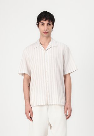 Chemise à manches courtes, beige clair, avec des rayures verticales blanches ; dotée d'un col évasé et d'une coupe décontractée. Fabriquée en tissu léger.