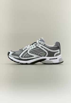 Grijze en witte sportschoen met meshstof, synthetische overlays, veters en een gewatteerde zool met het label "COMPLETE", zijwaarts weergegeven.