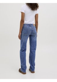 Modré džíny z denimu se straight fit, středním praním a viditelným šitím. Mají hnědou koženou nášivku na pasu a dvě zadní kapsy.