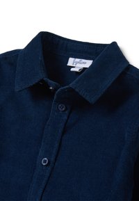 Navyblauwe corduroy blouse met een puntige kraag, knoopsluiting en subtiele ribbels met een merklabel binnenin de kraag.