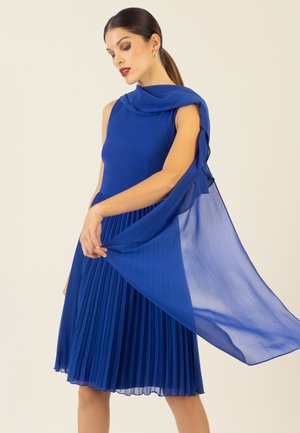 Blaues plissiertes Kleid mit einem schlanken Oberteil und fließendem, transparentem Cape. Hergestellt aus leichtem Stoff, mit einem knielangen Rock und glatter Textur.