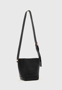 Sac seau en cuir noir avec une finition texturée, une bandoulière réglable, des accessoires dorés et un motif géométrique subtil sur le devant.