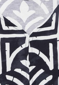 Schwarz-weißer Stoff mit einem geometrischen Muster aus klaren Linien und Formen, das eine strukturierte Baumwollmischung und scharfe Kanten präsentiert.