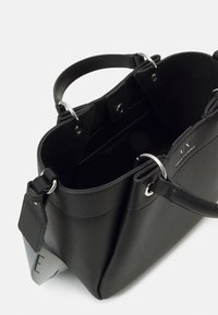 Schwarze Ledertasche mit strukturierter Oberfläche, silbernem Hardware, zwei Griffen und offenem Oberteil. Verfügt über ein Innenfach und Logodetail.