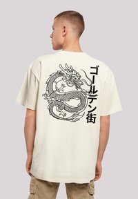Kurze Ärmel Creme T-Shirt mit großem schwarzen Drachenmotiv und japanischem Text auf der Rückseite, lässiger Schnitt und weicher Textur.
