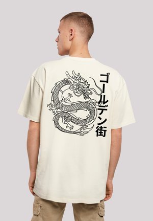 Short-sleeve cream t-shirt featuring a large black dragon graphic and Japanese text on the back, with a relaxed fit and soft texture.