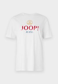 Balta medvilninė marškinė su apvaliu iškirpimu, trumpomis rankovėmis ir ryškiu daugiaspalviu tekstu: "JOOP!" raudona spalva ir "JEANS" mėlyna spalva po auksiniu emblema.