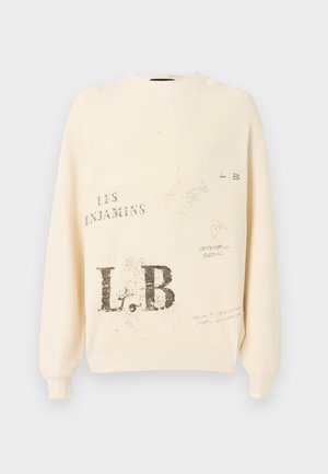 Sweat à couleur crème avec texture côtelée et manches longues. Comprend des textes et graphiques imprimés en gris, y compris "L.B" et "LES ENJAMINS."