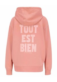 Růžová mikina s kapucí, na zadní straně s velkým bílým textem "TOUT EST BIEN" a pod ním názvem značky "SCOTCH & SODA".