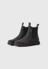 Botine Chelsea din piele neagră cu panouri elastice pe laterale, vârf rotunjit, taguri pentru tragere și talpă din cauciuc texturată. Finisaj neted cu detalii subtile.