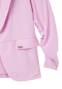 Blazer rosa chiaro realizzato in tessuto morbido, con un design strutturato, maniche lunghe, un dettaglio tasca e un'etichetta metallica.