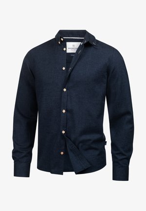 Męska ciemnogranatowa koszula na guziki z długimi rękawami i beżowymi guzikami, częściowo rozpięta, przedstawiona na białym tle.