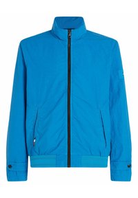Leichte blaue Jacke mit hohem Kragen, Frontreißverschluss, zwei Seitentaschen und kontrastierenden schwarzen Reißverschlussdetails. Mit Knopfmanschetten.