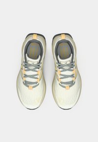 Kerged tossud, millel on kreemikas võrgust ülaosa, hallid detailid ja kollased kinnitused. Pehmendusega talla tekstuuriga haarduvus stabiilsuse tagamiseks.