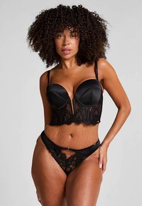 Zwarte lingerieset met een gestructureerde korset met kanten accenten en een bijpassende string. Soepele satijnen textuur met verstelbare bandjes.