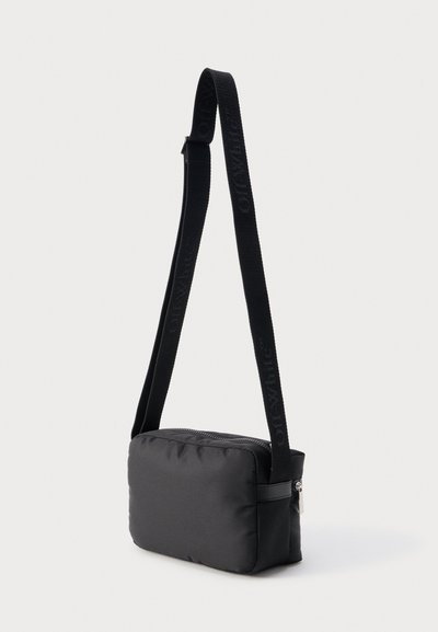 Μαύρη ορθογώνια τσάντα ώμου με ρυθμιζόμενο λουρί, διακοσμημένη με διακριτικό ανάγλυφο λογότυπο και επάνω φερμουάρ κλεισίματος.