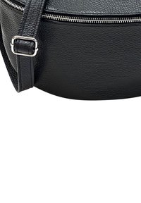 Zwarte leren schoudertas met een ronde vorm, gestructureerd oppervlak, ritssluiting en een verstelbare strap voor veilige draagbaarheid.