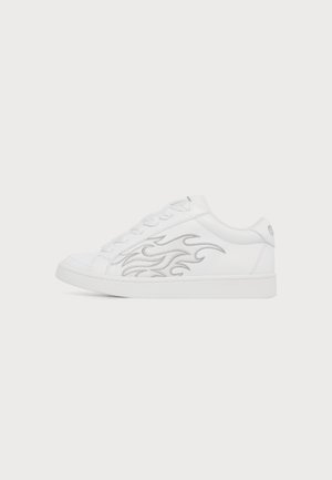 Λευκό sneaker χαμηλού τύπου με λευκά κορδόνια και ασημί σχέδιο φλόγας στο πλάι, εμφανιζόμενο από την εξωτερική πλευρά σε απλό φόντο.