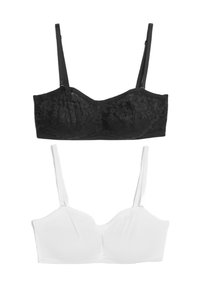 Sostén negro de encaje con detalles de aros y tirantes ajustables, superpuesto a un sostén de tela blanca suave con una forma y diseño de tirantes similar.