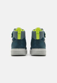 Høye sneakers i blå og grå semsket skinn, med en grønn løftekrok og borrelåsrem. Tykk gummisåle med teksturert mønster.