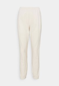 Lichtcrème sweatpants gemaakt van zachte stof, met een elastische tailleband en taps toelopende boorden bij de enkels. Geen patronen of extra details.