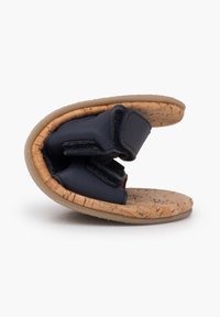 Pantofle s korkovou podrážkou a měkkým horním dílem v námořnické modři. Obsahují suché zipy a flexibilní, tvarovaný design pro pohodlí.