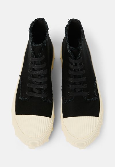 Scarpe alte in tela nera con bordi sfilacciati, lacci testurizzati e suole in gomma crema con design rigato.