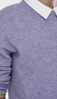 Liila neulepaita, jossa on teksturoitu neulekangas, pyöreä pääntie ja pitkät hihat, päällä valkoinen kauluspaita.