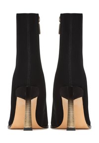 Bottines noires avec un design ajusté, texture ressemblant à du daim, détail de fermeture éclair en métal à l'arrière et un talon métallique élégant.