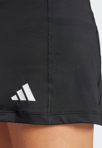 Black athletic shorts with a smooth texture, featuring white Adidas logo, visible stitching, and a fitted design.