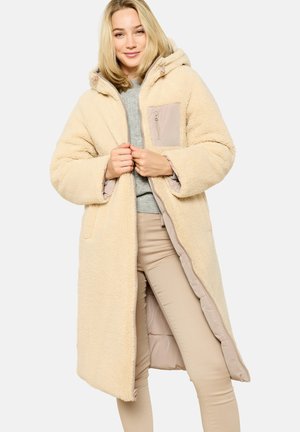 Beige pitkä takki, joka on valmistettu teksturoidusta tekoturkista, jossa on huppu, vetoketjusuljenta sekä erottuva beige tasku. Pehmeä, lämmin ja ylisuuri muotoilu.