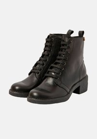 Botas de tobillo de cuero negro con cordones, un tacón grueso y lengüetas en la parte posterior, mostradas en un ángulo ligeramente inclinado sobre un fondo blanco.