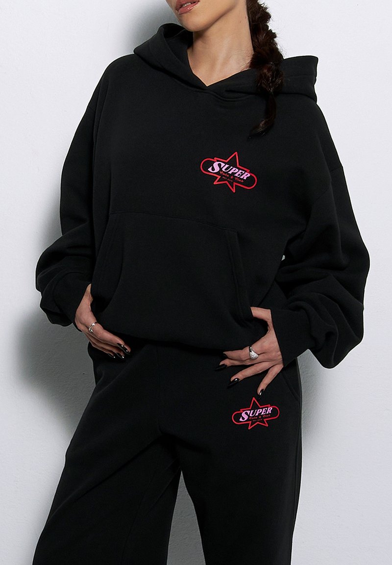 Czarna bluza z kapturem wykonana z mieszanki bawełny, z przednią kieszenią oraz czerwonym logo z wzorem gwiazdy na klatce piersiowej.