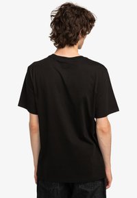 Černé bavlněné tričko s kruhovým výstřihem a krátkými rukávy, s volným střihem a hladkou texturou. Minimalistický design bez grafik.