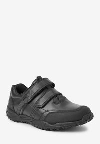 Baskets de sport noires en cuir et matériaux synthétiques, avec deux bandes Velcro, un bout arrondi et une semelle texturée pour une meilleure adhérence.