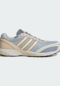 Ανοιχτό μπλε παπούτσι για τρέξιμο με μπεζ λεπτομέρειες, λευκές και μπεζ ρίγες σ το πλευρό, πλέγμα στο πάνω μέρος και μαλακή σόλα.