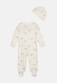 Cremefarvet babyoverall og matching hat med små dyreprint i orange og grøn. Blødt stof med lange ærmer og foddesign.