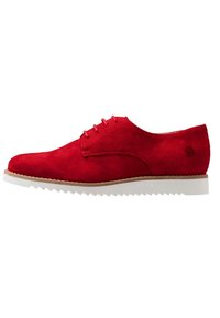 Červená semišová bota s hladkým povrchem, vybavená bílou gumovou podrážkou, šněrovacím designem a prošívaným okrajem. Jemný detail loga na patě.