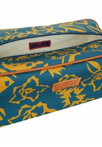 Borsa in tessuto color teal caratterizzata da un motivo floreale giallo, un'etichetta in pelle, una chiusura con zip e un interno beige a contrasto.