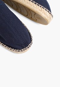 Marinevævede espadrilles med rund tå, sål af jute reb og kontraststing langs den øverste kant. Struktureret stoffinish.