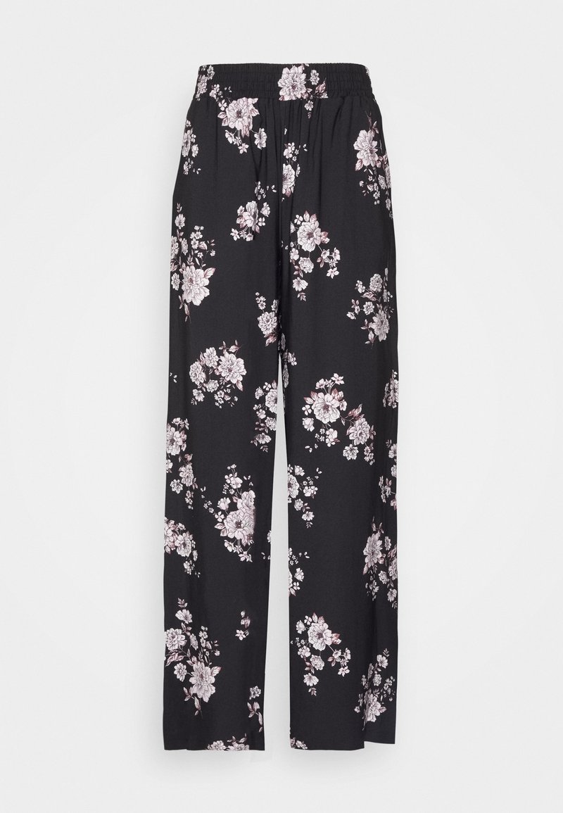 Pantalon noir à jambes larges avec imprimé floral blanc et rose clair et taille élastique sur fond uni.
