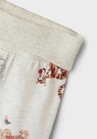 Katoenen pyjamashorts met een geribbelde elastische tailleband; voorzien van een beige stof bedrukt met speelse tijgerpatronen in oranje en bruin.