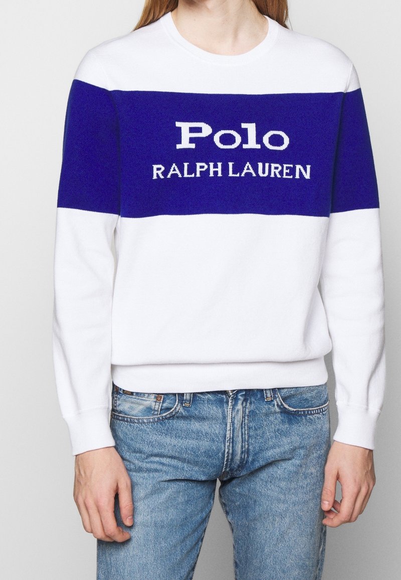 Weißer Pullover mit blauem Horizontalstreifen, der "Polo RALPH LAUREN" in weißem Text zeigt. Rippbündchen und Saum, weiches Strickmaterial.