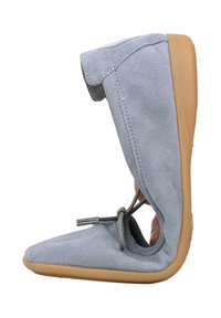 Lichtgrijze suède schoen met flexibele, lichtbruine rubberen zool die naar boven gebogen is en daarmee de zachtheid toont, met een veter die bovenop is gestrikt.