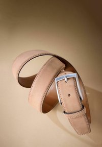 Ceinture en suède beige avec une boucle en argent rectangulaire. Présente des coutures soignées et une texture lisse. Ajustable avec plusieurs trous pour le réglage.