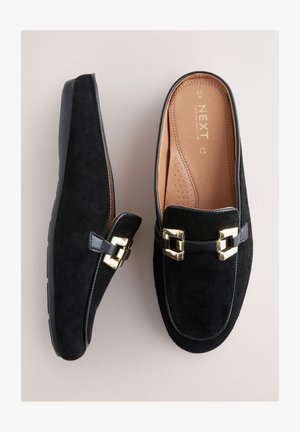 Mocasini negri din piele întoarsă, cu accente metalice aurii. Prezintă o talpă interioară netedă din piele și o talpă exterioară din cauciuc. Design slip-on cu vârf rotund.