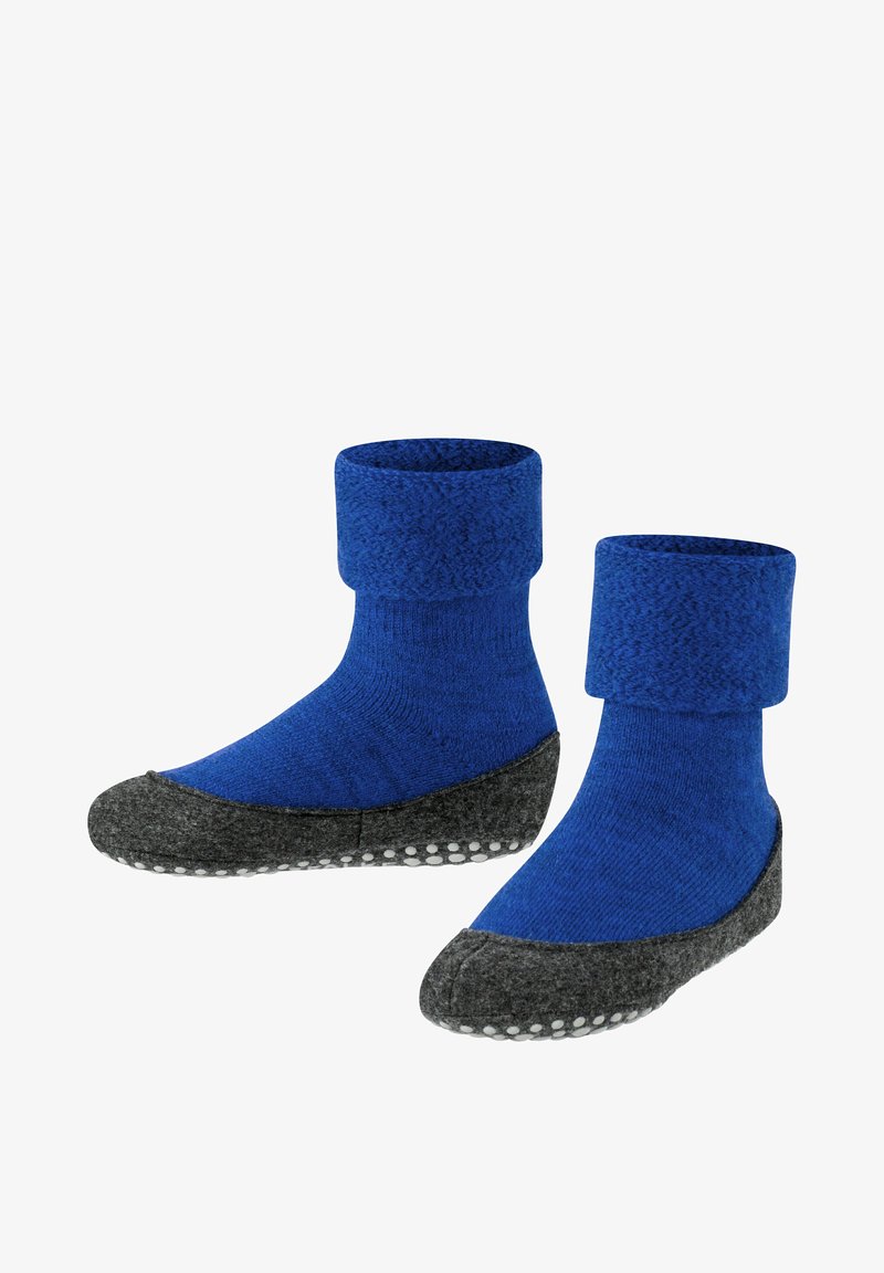 Calcetines de punto azules con un puño doblado, que presentan una suela de fieltro gris y una superficie texturizada, realzada con puntos antideslizantes blancos en la parte inferior.