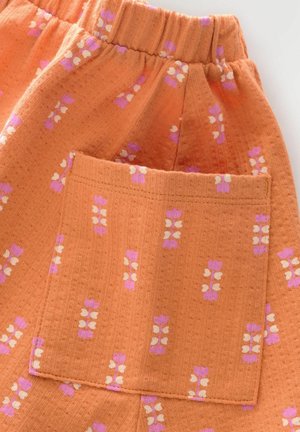 Oranga vävda shorts med elastisk midja och en lappficka, med rosa och vita blommönster genom hela.